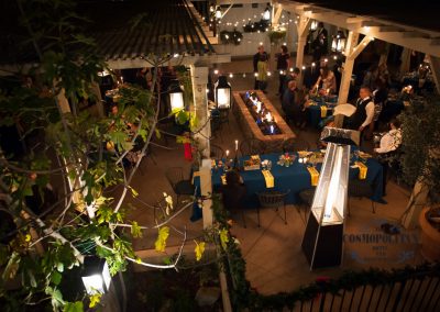 Cosmo courtyard at night with outdoor heaters, a fire pit people being served dinner