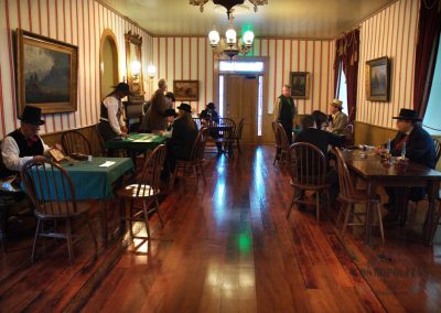 The Grand Salon with card players dressed in old western attire